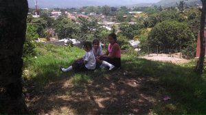 3 Girls sitting on hillside